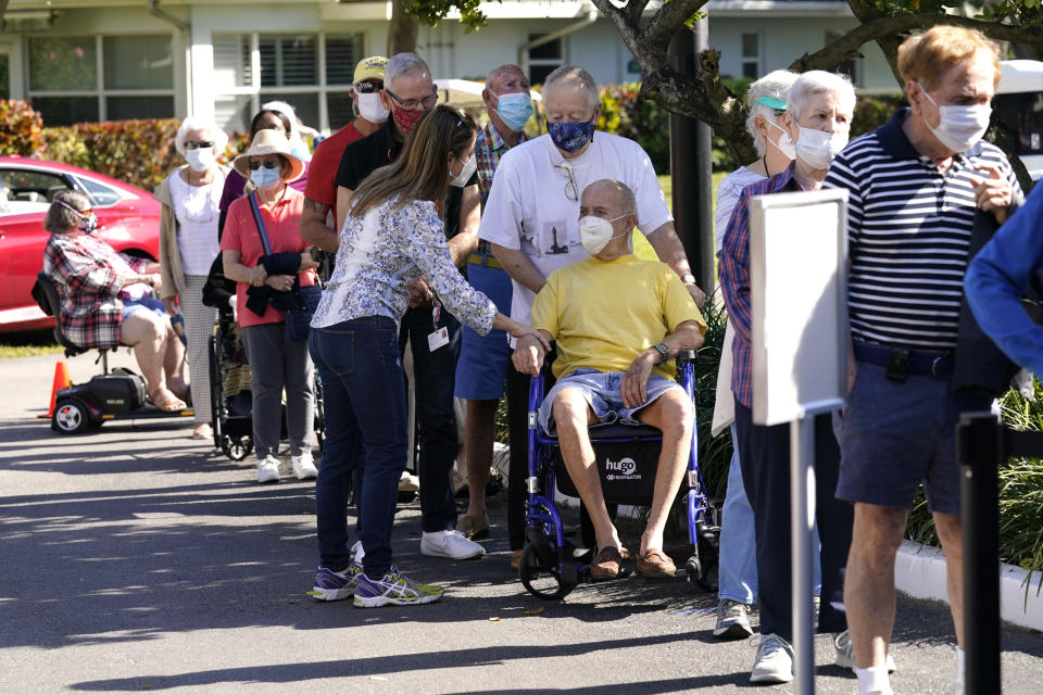 Robert Birkenmeier, center, waits in line with other residents to receive the Pfizer-BioNTech COVID-19 vaccine, Tuesday, Jan. 19, 2021, at John Knox Village in Pompano Beach, Fla. (AP Photo/Lynne Sladky)