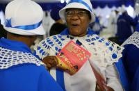 Faithful reacts as she holds a pamphlet on coronavirus disease (COVID-19) at the end of a service