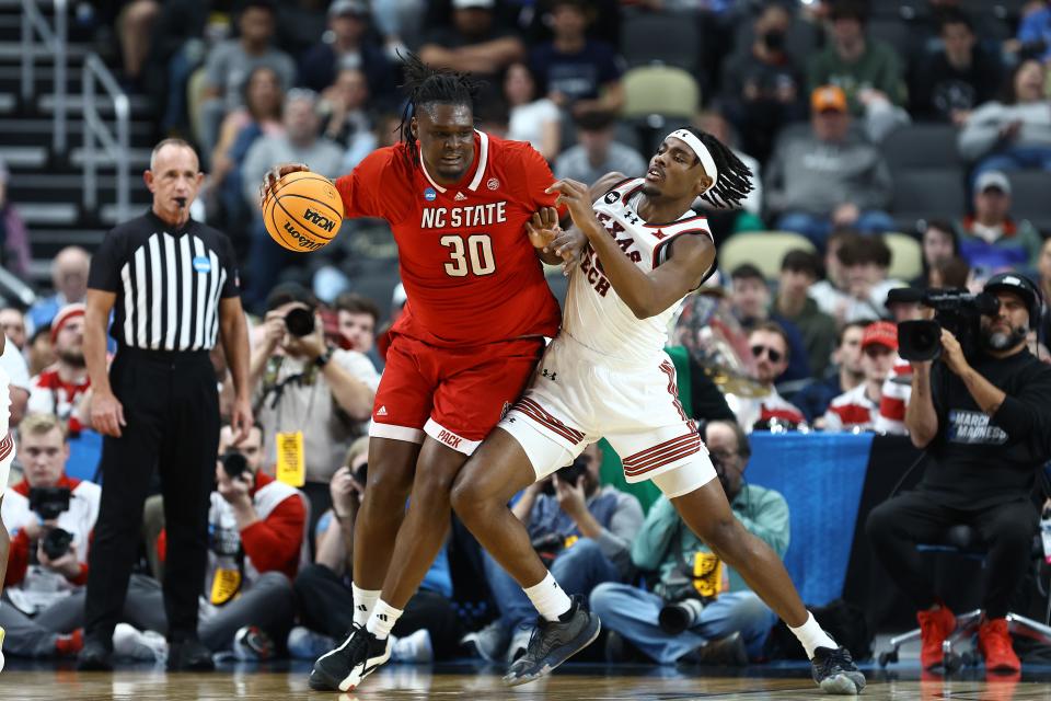 DJ Burns Jr. of North Carolina State backs down Robert Jennings of the Texas Tech during the second half in the first round of the NCAA Men's Basketball Tournament at PPG PAINTS Arena on March 21, 2024 in Pittsburgh, Pennsylvania.