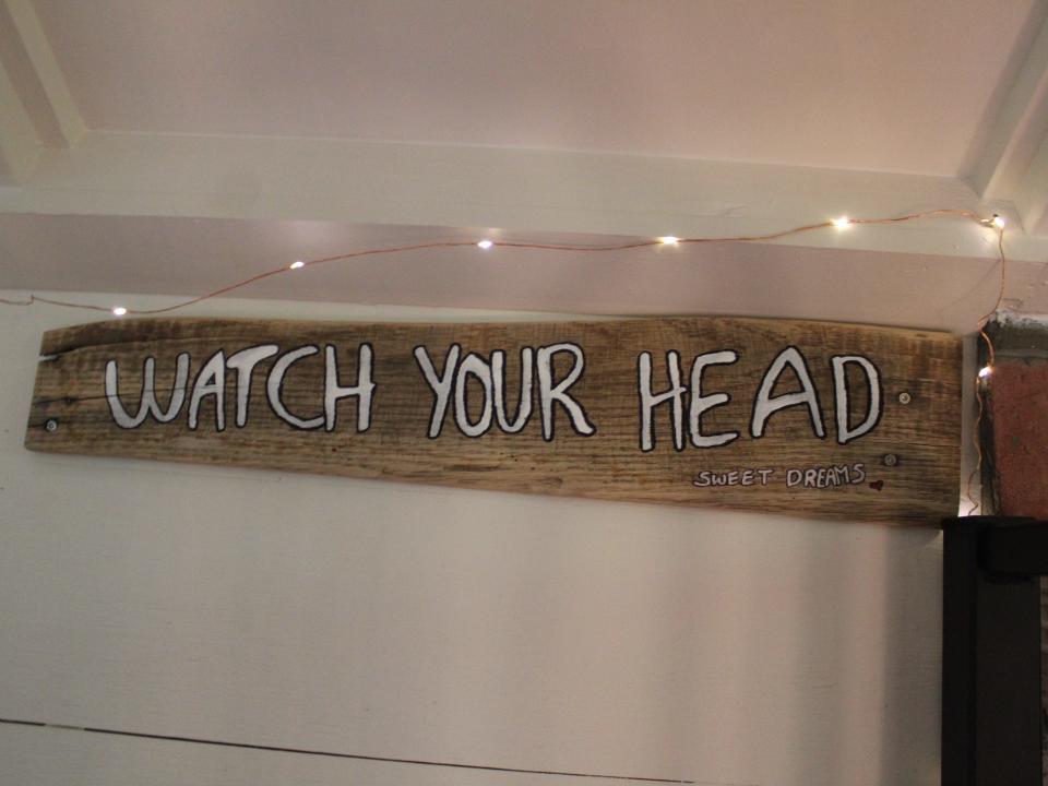 a wooden sign that reads "watch your head"