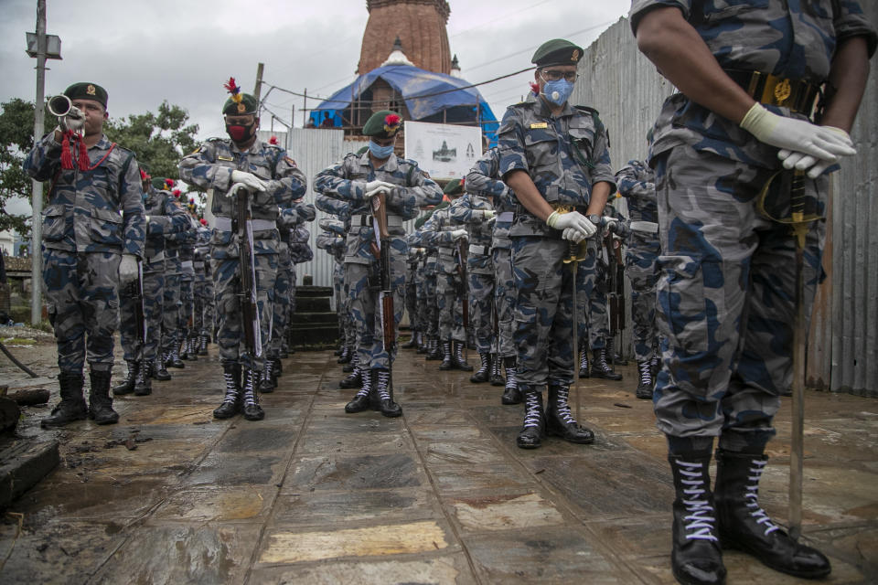 Nepalese Armed Police Force provides guard of honor during the funeral of veteran Nepalese Sherpa guide Ang Rita, in Kathmandu, Nepal, Wednesday, Sept. 23, 2020. Ang Rita, who was the first person to climb Mount Everest 10 times has died Monday at age 72 after a long illness. (AP Photo/Niranjan Shrestha)