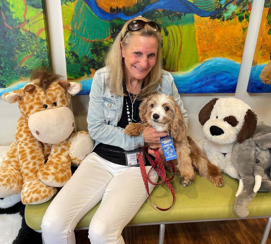 Emerald Coast Children's Advocacy Center volunteer Barb Whitman is seen with her therapy dog Miracle.