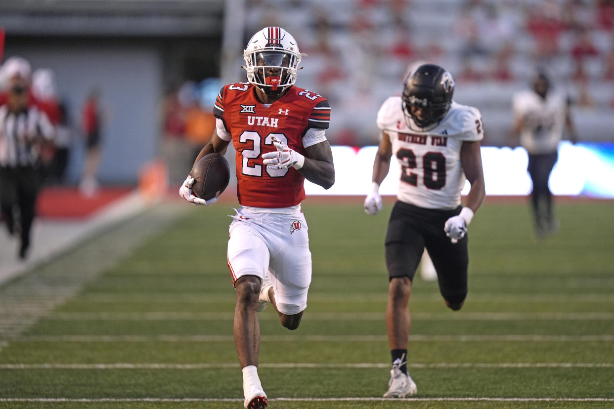 Utah running back Dijon Stanley (23) outruns Southern Utah safety Kameron Rocha (28) as he carries the ball for a touchdown in the first half of an NCAA college football game Thursday, Aug. 29, 2024, in Salt Lake City. (AP Photo/Rick Bowmer)