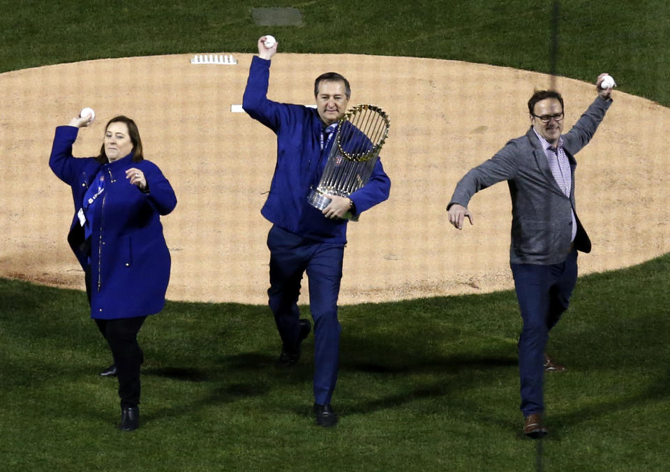 Laura Ricketts, left, Tom Ricketts, center, and Todd Ricketts throw the ceremonial first pitch before a baseball game between the Chicago Cubs and the Los Angeles Dodgers day, Monday, April 10, 2017, in Chicago. (AP Photo/Nam Y. Huh)