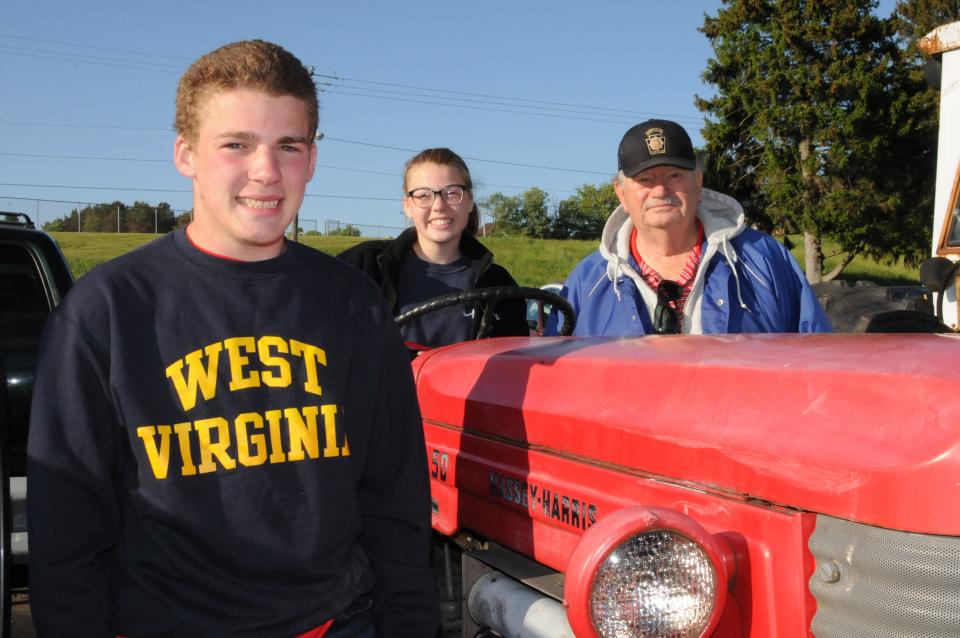 Don Shinn with his grandchildren, Carly Richard, a senior, and Westley Richard, in junior high, at the Somerset Area High School parking lot after driving tractors to school Thursday.