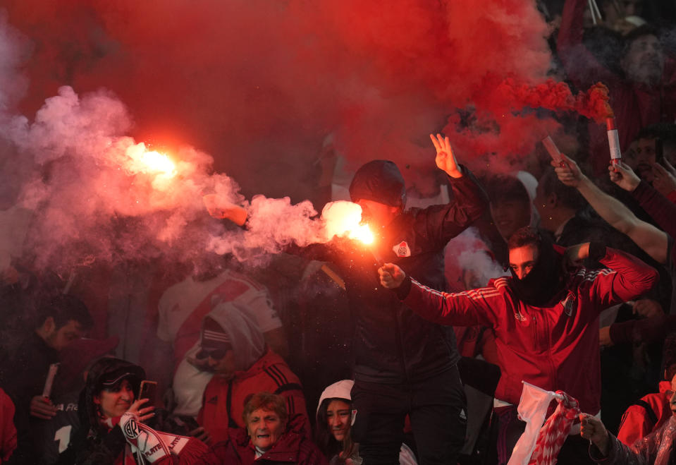 A fan of River Plate holds a flare in the stands during a Copa Libertadores round of sixteen, second leg soccer match against Velez Sarsfield at Monumental stadium in Buenos Aires, Argentina, Wednesday, July 6, 2022. (AP Photo/Natacha Pisarenko)
