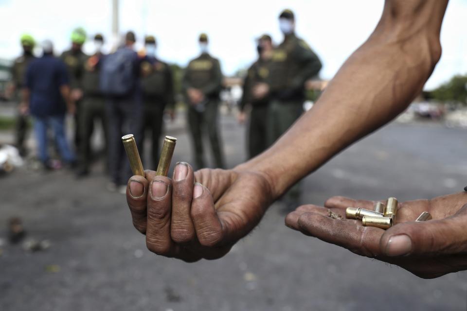 Un hombre muestra casquillos de bala que, según dijo, fueron disparados contra manifestantes durante las protestas antigubernamentales en Cali, Colombia, el martes 11 de mayo de 2021. (Foto AP/Andrés González)