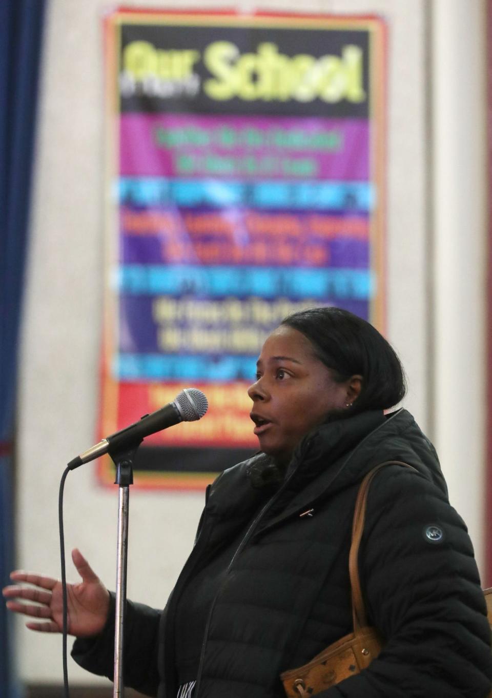 Renika Hereford, a parent with a fourth grader at Firestone Park, asks a question during a community meeting Monday about a proposed redistricting plan for Akron schools.