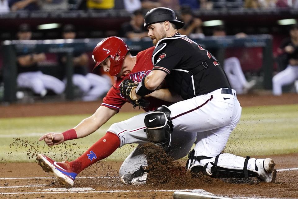 Arizona Diamondbacks catcher Cooper Hummel, right, tags out Philadelphia Phillies' Rhys Hoskins at home plate during the first inning of a baseball game Wednesday, Aug. 31, 2022, in Phoenix. (AP Photo/Ross D. Franklin)