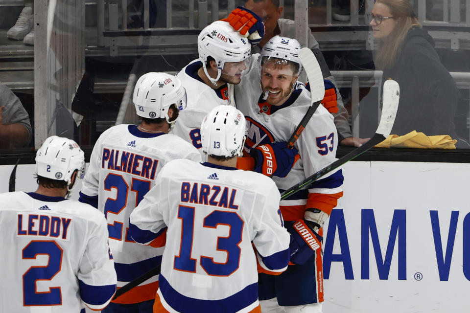 Teammates surround New York Islanders' Casey Cizikas after he scored the winning goal in overtime of Game 2 of an NHL hockey second-round playoff series against the Boston Bruins, Monday, May 31, 2021, in Boston. (AP Photo/Winslow Townson)