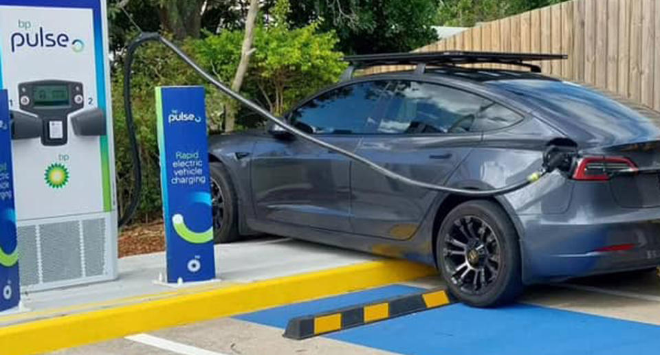 Dark grey tesla charging vehicle at BP Pulse charging bay. 