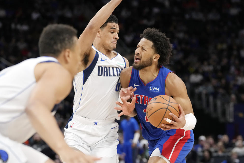 Detroit Pistons guard Cade Cunningham (2) is defended by Dallas Mavericks guard Josh Green during the first half of an NBA basketball game, Saturday, March 9, 2024, in Detroit. (AP Photo/Carlos Osorio)