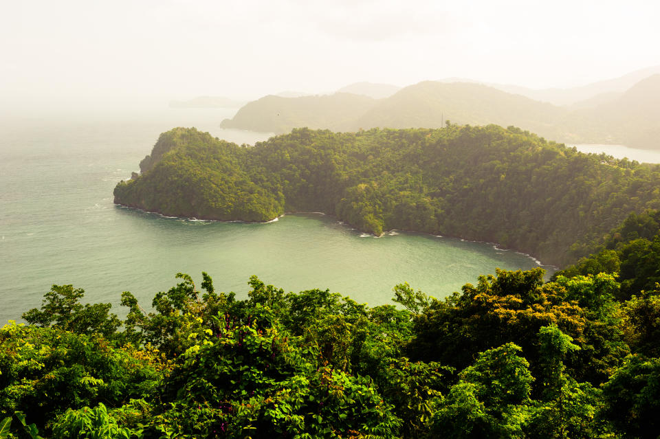 Golden light filtering through a brief rain shower over lush peninsulas jutting into the Caribbean Sea at Maracas Bay, Trinidad