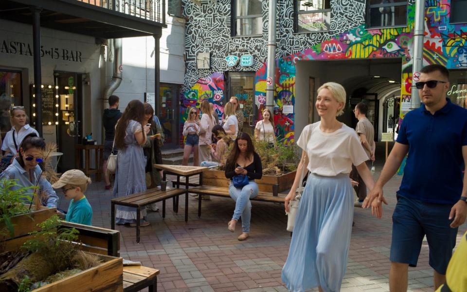 Visitors walk in a court, popular with its cafes and restaurants, which were recently opened for a take-away service, in St. Petersburg - Maria Turchenkova