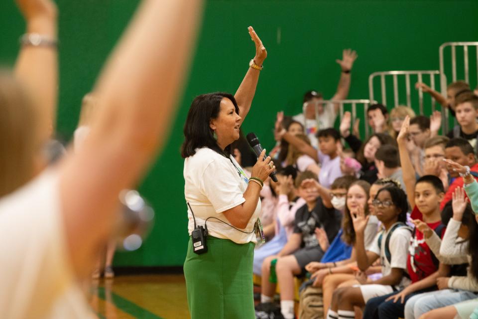 French Middle School principal Kelli Hoffman gets everybody's attention by giving a "Falcon Five" during an orientation for the first day of school Thursday.