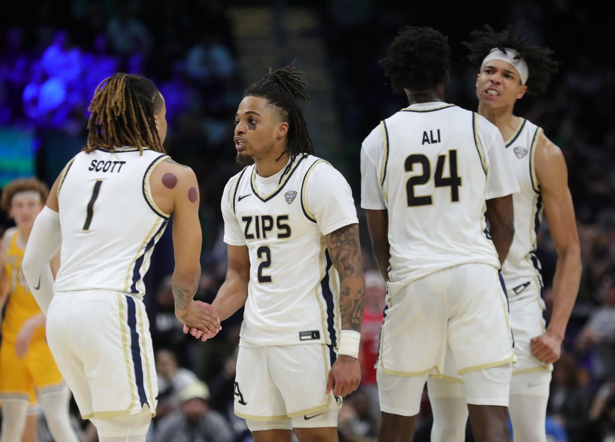 Akron Zips guard Greg Tribble (2) celebrates as time winds down with Akron Zips guard Shammah Scott (1) during the second half of the Mid-American Conference Tournament championship game at Rocket Mortgage FieldHouse, Saturday, March 16, 2024, in Cleveland, Ohio.