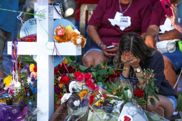 A woman grieves over a memorial for the Uvalde Massacre