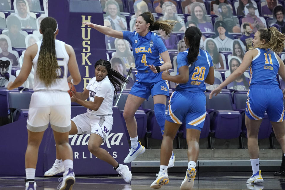 UCLA guard Lindsey Corsaro (4) and guard Charisma Osborne (20) watch as Washington guard Tameiya Sadler, second from left, looks to pass during the second half of an NCAA college basketball game, Sunday, Feb. 7, 2021, in Seattle. (AP Photo/Ted S. Warren)