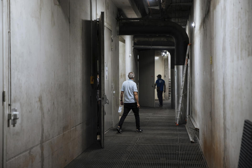 Employees walk through the cold transmission machine room of the Louvre Museum in Paris, Tuesday, July 26, 2022. The museum benefits from one of Paris' best-kept secrets, an underground cooling system that's helped the Louvre cope with the sweltering heat that has broken temperature records across Europe. (AP Photo/Lewis Joly)