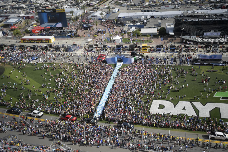 FILE - Fans watch as drivers walk down a runway during driver introductions before the NASCAR Daytona 500 auto race at Daytona International Speedway Sunday, Feb. 17, 2019, in Daytona Beach, Fla. The party has been canceled during the pandemic but the playoffs go on, starting Sunday, Sept. 6, 2020, without any of the pomp and circumstance.(AP Photo/Phelan M. Ebenhack, File)