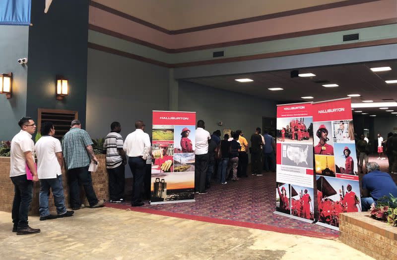 Job seekers line up at a job fair of an oil services giant Halliburton at the MCM Grande Fundome hotel in Odessa Texas