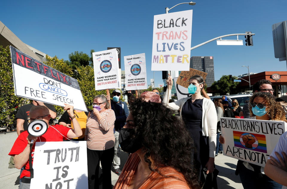 People holding trans rights signs engage with a man holding a sign arguing for free speech outside Netflix HQ (Mario Anzuoni / Reuters)