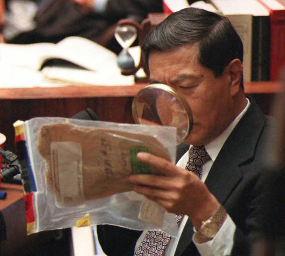 <div class="inline-image__caption"><p>Forensic scientist Dr. Henry Lee uses a magnifying glass to look at blood stains on an envelope used to collect the eyeglasses found at the Bundy crime scene during Hank Goldberg's cross-examination of Lee in the O.J. Simpson murder trial.</p></div> <div class="inline-image__credit">Getty</div>