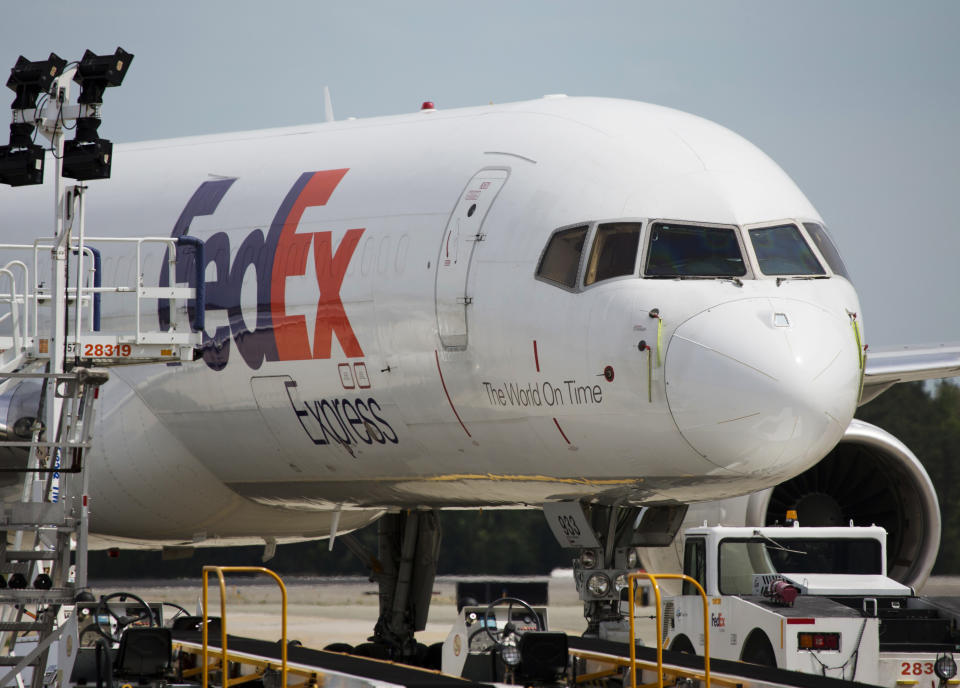 FILE- In this April 18, 2017, file photo, a FedEx cargo plane sits idle during the day at Richmond International Airport in Sandston, Va. FedEx says one of its pilots was detained in China after an item was found in his luggage before he boarded a commercial flight. The company said Thursday, Sept. 19, 2019 the pilot was later released, and it is working with Chinese authorities to understand what happened at the airport in Guangzhou, in southern China.(AP Photo/Steve Helber, File)