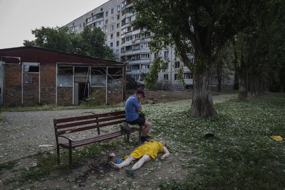 2022年7月7日，烏克蘭哈爾科夫，一名男子坐在一名女子的遺體旁哭泣。