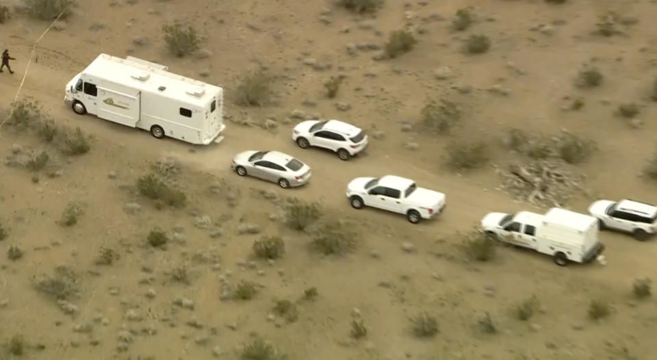 This aerial still image from video provided by KTLA shows law enforcement vehicles where several people were found shot to death in El Mirage, Calif. on Wednesday, Jan. 24, 2024. Deputies found the bodies of six people at a remote dirt crossroads in the Mojave Desert in Southern California, a scene described as so grisly that TV stations blurred some of the images captured by their helicopter overhead. (KTLA via AP)