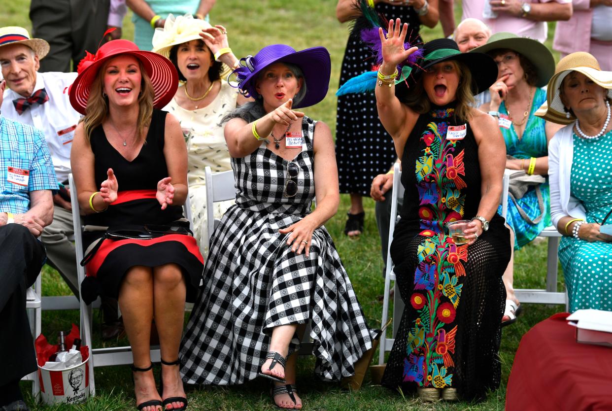 Race fans cheer and point at the television on the porch of the Swenson House as the winning horse in the Kentucky Derby crosses the finish line May 6, 2023.