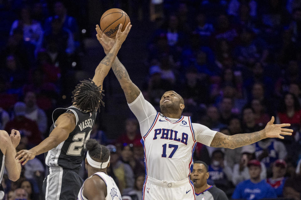 San Antonio Spurs guard Devin Vassell (24) and Philadelphia 76ers forward P.J. Tucker (17) reach for the ball in the first half of an NBA basketball game, Saturday, Oct. 22, 2022, in Philadelphia. (AP Photo/Laurence Kesterson)