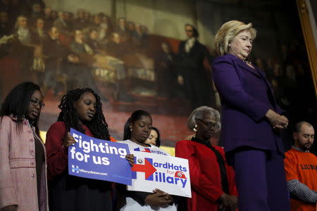 U.S. Democratic presidential candidate Hillary Clinton and audience members bow their heads for the victims of the mass shooting at a Colorado Planned Parenthood clinic, during a campaign rally at Faneuil Hall in Boston, Massachusetts November 29, 2015. REUTERS/Brian Snyder