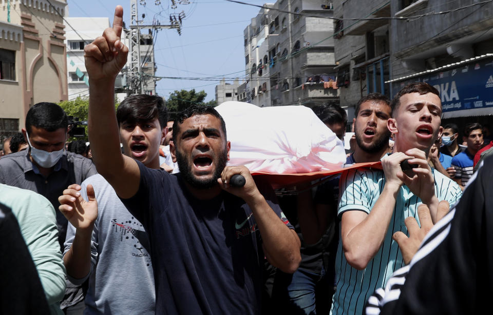 Mourners chant Islamic slogans while they carry the body of Amira Soboh, and her 19-year-old disabled son Abdelrahman, who were killed in Israeli airstrikes at their apartment building, during their funeral at the Shati refugee camp, in Gaza City, Tuesday, May 11, 2021. (AP Photo/Adel Hana)