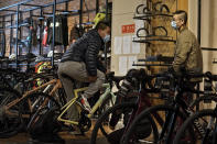 Customers wearing face masks to help curb the spread of the coronavirus chat each other as they try out the American bicycle brand at a retail shop in Beijing Tuesday, March 2, 2021. Chinese leaders are shifting focus from the coronavirus back to long-term goals of making China a technology leader at this year's highest-profile political event, the meeting of its ceremonial legislature, amid tension with Washington and Europe over trade, Hong Kong and human rights. (AP Photo/Andy Wong)