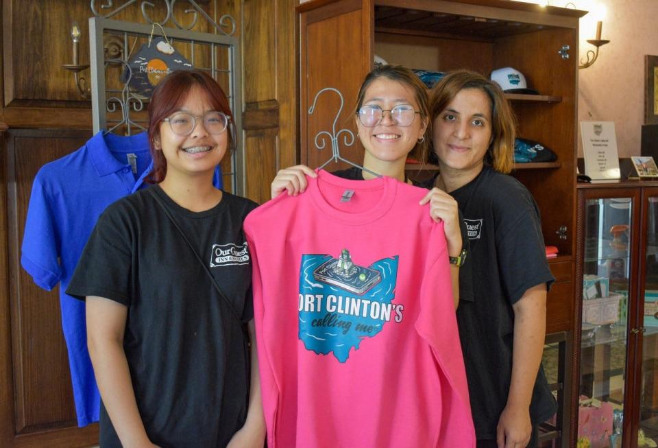 Our Guest Inn & Suites employees, from left, Sitanan “Chat” Tongmee, Boonnapa “Boon” Thamanasart and Nigar “Irem” Aras show off the “Port Clinton’s Calling Me” merchandise that is available at the hotel and through an online store.