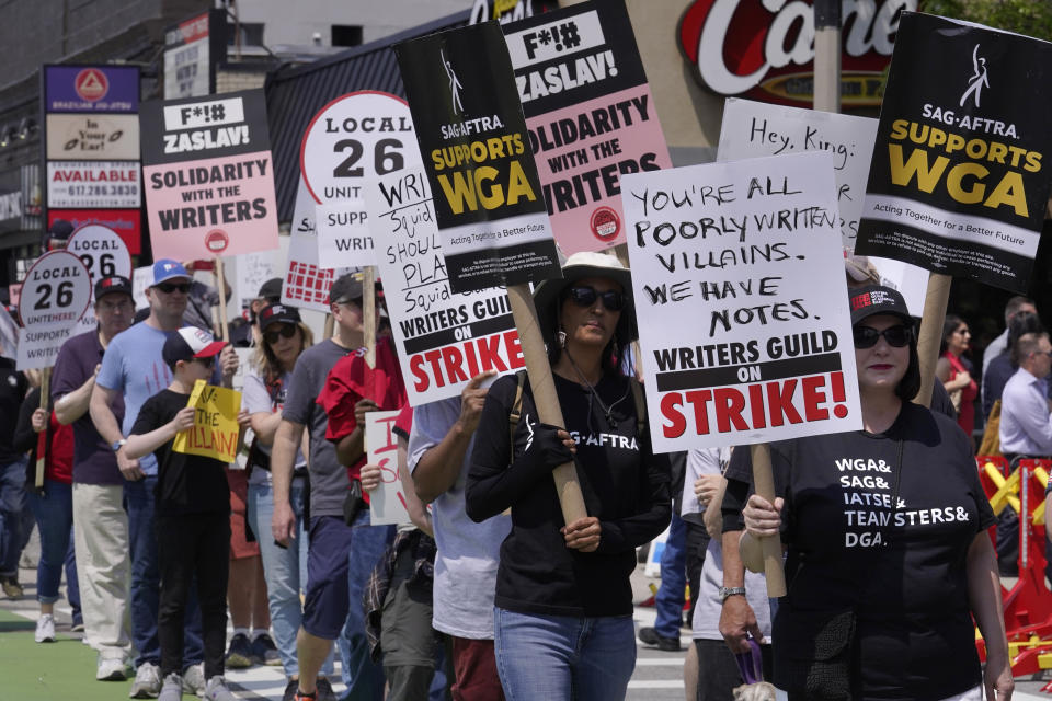 Protesters supporting the Hollywood writers' strike march in a picket line outside an entrance to Boston University commencement ceremonies, Sunday, May 21, 2023, in Boston. David Zaslav, president and CEO of Warner Bros. Discovery, delivered an address during ceremonies Sunday. (AP Photo/Steven Senne)