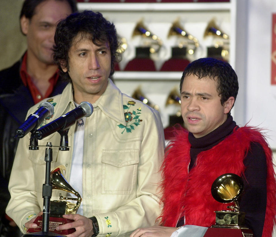 En esta foto del 30 de octubre del 2001, Héctor Buitrago, a la izquierda, del grupo Aterciopelados, recibe el Latin Grammy al mejor álbum de rock de un dúo o grupo por "Gozo poderoso" durante una conferencia de prensa en Los Ángeles. Los ganadores de los Latin Grammy se anunciaron ese año en una conferencia luego que la ceremonia se tuvo que cancelar por los ataques terroristas del 11 de septiembre. (AP Foto/Nick Ut, Archivo)