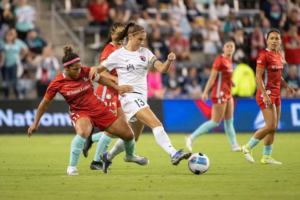 San Diego Wave FC forward Alex Morgan (13) handles the ball while defended by Kansas City Current midfielder Desiree Scott (11) at Children's Mercy Park in a June game.