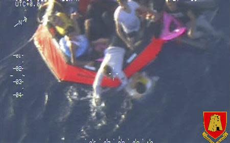 Migrants climb aboard a life raft deployed by an Armed Forces of Malta aircraft some 60 nautical miles south of the Italian island of Lampedusa October 11, 2013, in this picture released by the Armed Forces of Malta. REUTERS/Armed Forces Malta Press Office/Handout via Reuters