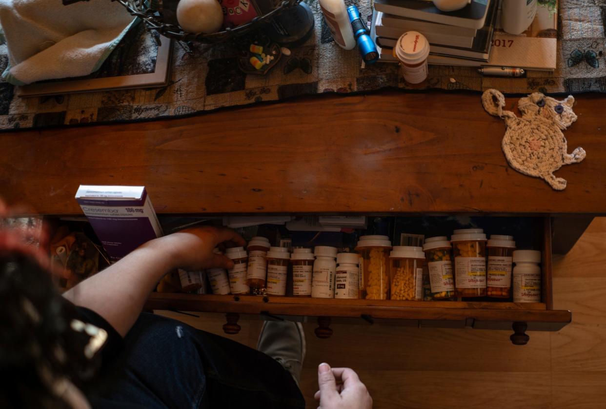 Courtney Cirone, 41, of Marion, goes through medications she is taking in a drawer near the couch at her home in northern Michigan where she developed a spore-caused fungal disease called blastomycosis and histoplasmosis. "I'm tired of taking pills every day and then taking another pill because that pill's causing side effects. I don't like this game that I'm in of taking more meds," said Cirone.