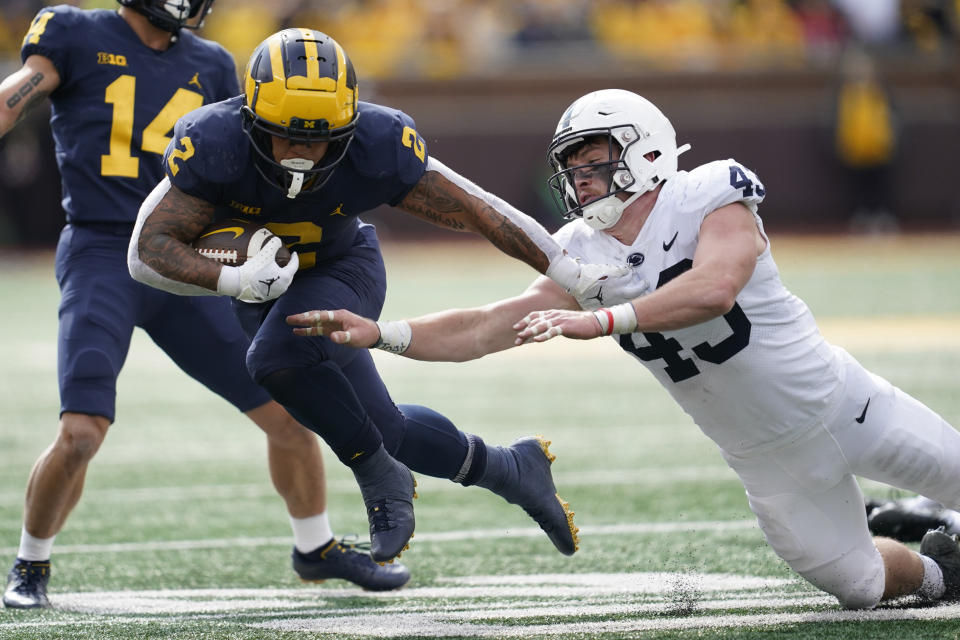 Michigan running back Blake Corum (2) bounces off the tackle of Penn State linebacker Tyler Elsdon (43) in the first half of an NCAA college football game in Ann Arbor, Mich., Saturday, Oct. 15, 2022. (AP Photo/Paul Sancya)