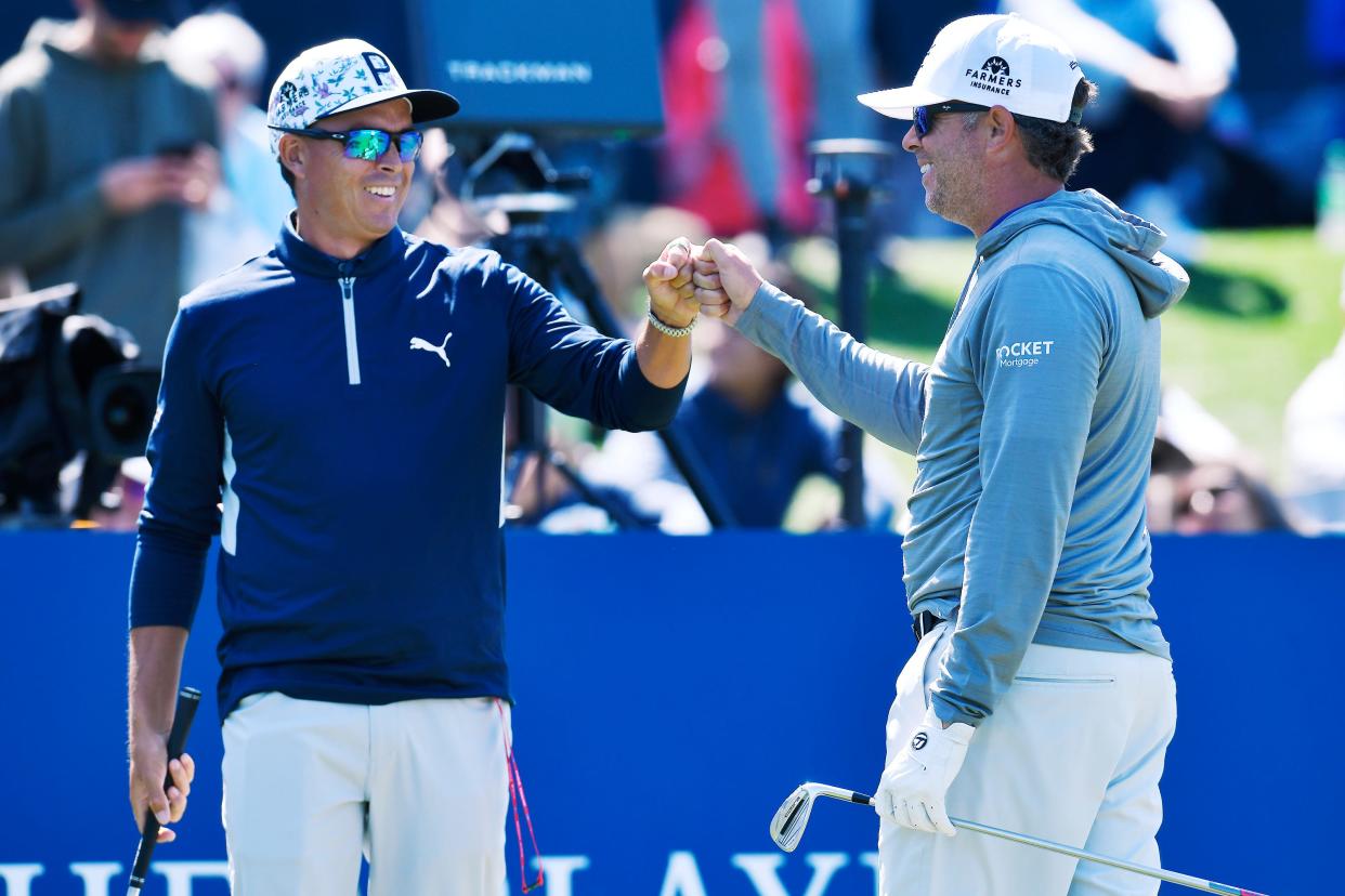 Rickie Fowler bumps first with his caddie Ricky Romano after Romano's chip shot to the island green on hole 17 during the caddie competition Wednesday. Sunny skies with a cool breeze greeted players and fans during Wednesday's practice session at THE PLAYERS Championship in Ponte Vedra Beach, FL, March 8, 2023. [Bob Self/Florida Times-Union]