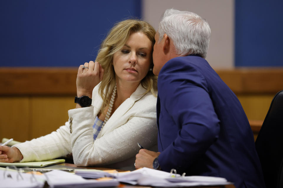 Attorney John Merchant speaks to his wife and co-counsel Ashleigh Merchant during a hearing on the Georgia election interference case, Friday, March, 1, 2024, in Atlanta. The hearing is to determine whether Fulton County District Attorney Fani Willis should be removed from the case because of a relationship with Nathan Wade, special prosecutor she hired in the election interference case against former President Donald Trump.(AP Photo/Alex Slitz, Pool)