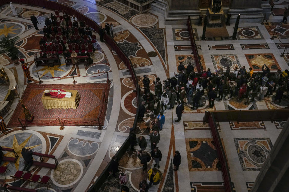 People queue to see off late Pope Emeritus Benedict XVI lying out in state inside St. Peter's Basilica at The Vatican where thousands went to pay their homage Tuesday, Jan 3, 2023. Pope Benedict, the German theologian who will be remembered as the first pope in 600 years to resign, has died, the Vatican announced Saturday, Dec. 31, 2022. He was 95. (AP Photo/Antonio Calanni)