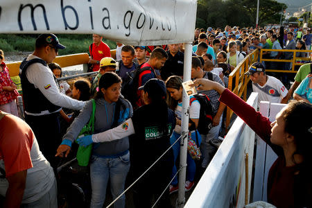 Colombian migration officers check the identity documents of people trying to enter Colombia from Venezuela, at the Simon Bolivar International bridge in Villa del Rosario, Colombia August 25, 2018. REUTERS/Carlos Garcia Rawlins