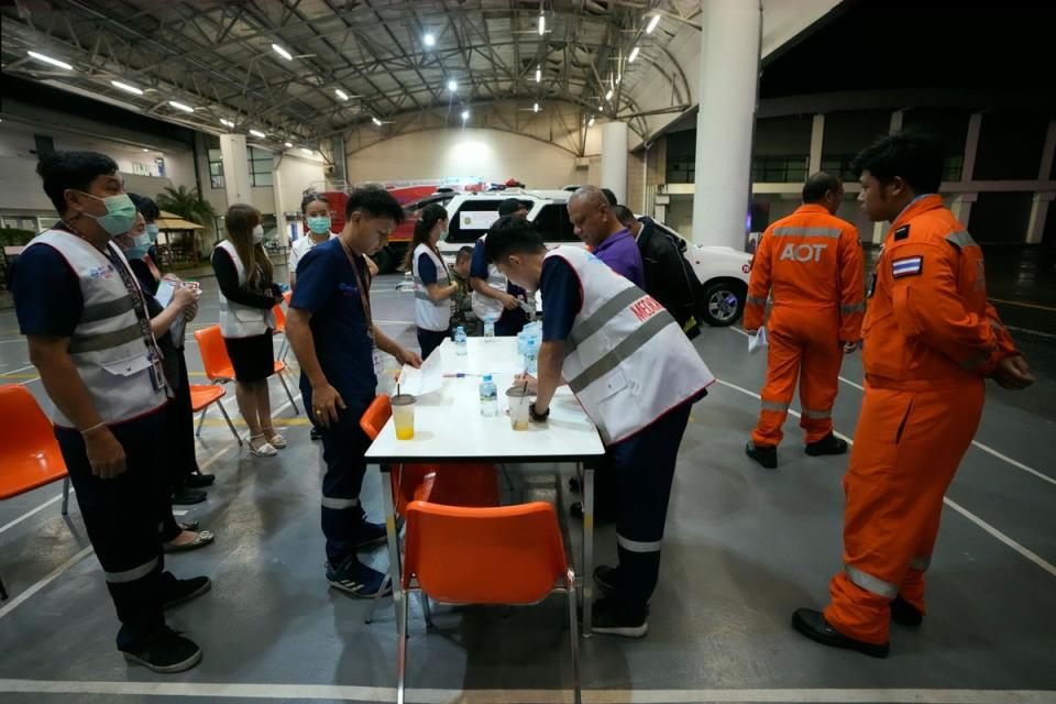 Members of a rescue team discuss after a London-Singapore flight was diverted to Bangkok due to severe turbulence, in Bangkok (AP)