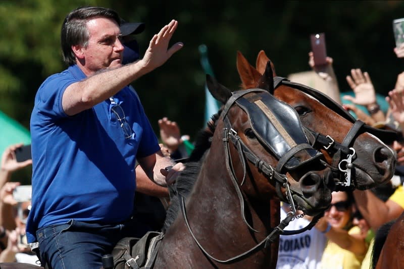 Brazil's President Jair Bolsonaro rides a horse during a meeting with supporters protesting in his favor, amid the coronavirus disease (COVID-19) outbreak, in Brasilia