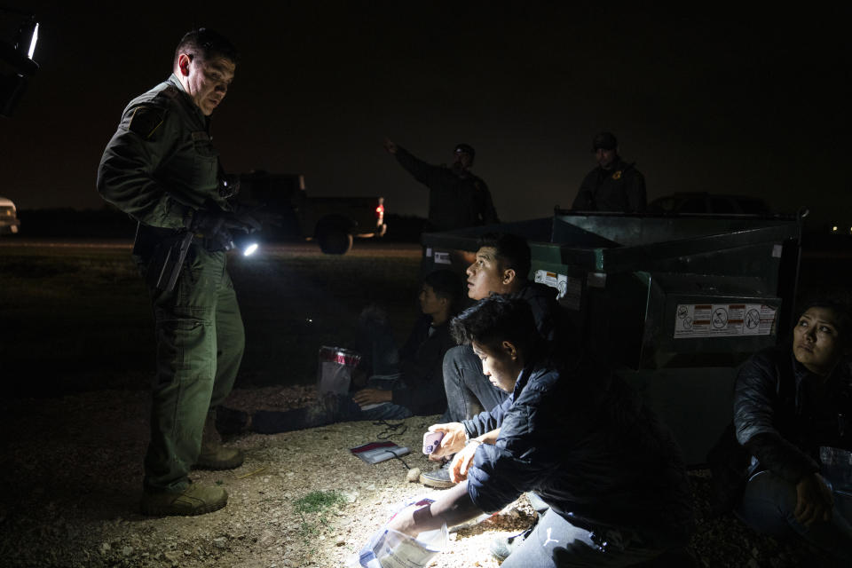 Migrants that were trying to evade U.S. Border Patrol agents, wait to be processed in Granjeno, Texas, early Thursday, May 4, 2023. In almost two weeks the Rio Grande Valley Sector has been the busiest sector averaging nearly 2,000 apprehensions a day. (AP Photo/Veronica G. Cardenas)
