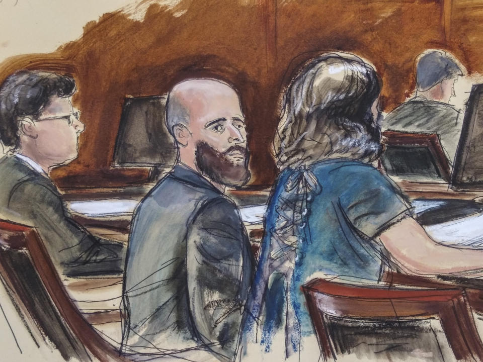 In this Wednesday March 4, 2020 courtroom sketch Joshua Schulte, center, is seated at the defense table flanked by his attorneys during jury deliberations in New York. Joshua Schulte, a former CIA software engineer charged with leaking government secrets to WikiLeaks says it's cruel and unusual punishment that he's awaiting trial in solitary confinement, housed in a vermin-infested cell of a jail unit where inmates are treated like “caged animals." In court papers Tuesday, Jan. 19, 2021 Schulte maintained he is held in conditions “below that of impoverished persons living in third world countries.” (Elizabeth Williams via AP)